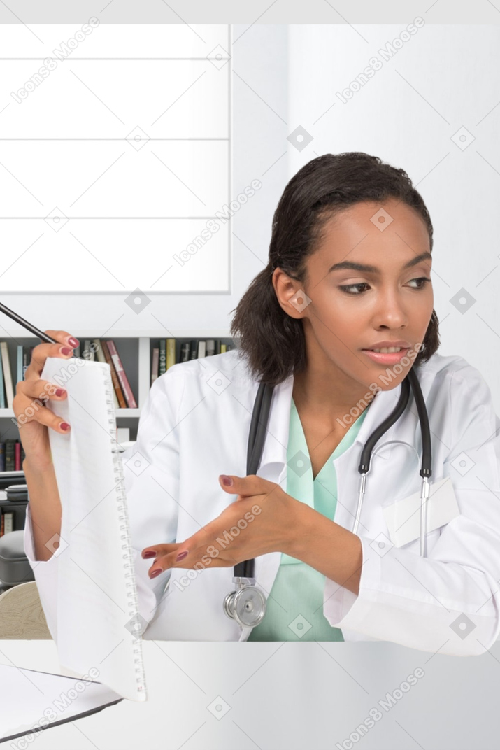 A doctor pointing at notepad
