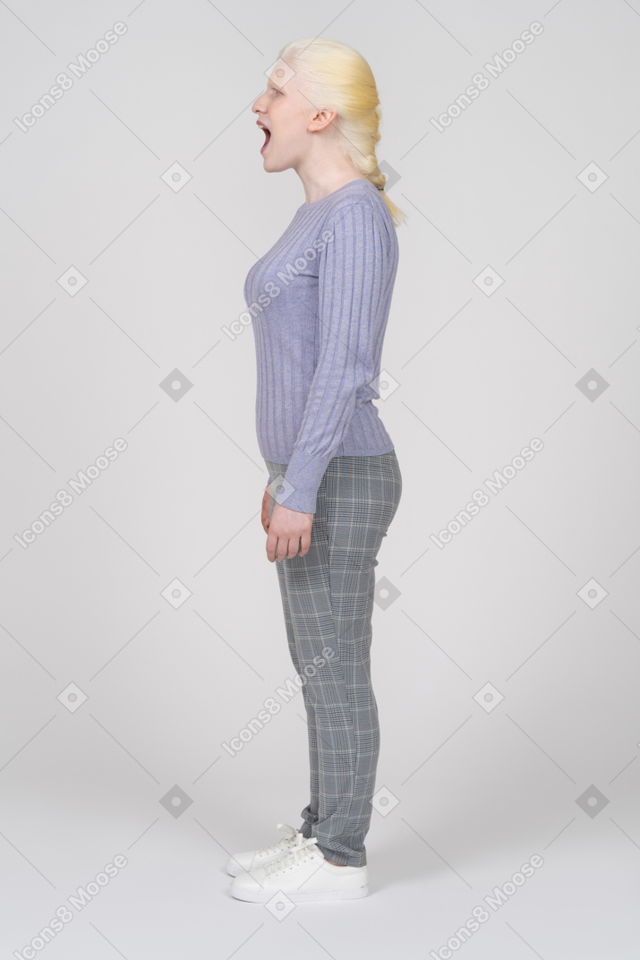 Side view of a woman in casual clothes opening her mouth