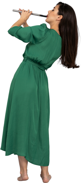 Vista posterior de una joven en vestido verde tocando la flauta mientras se inclina a un lado