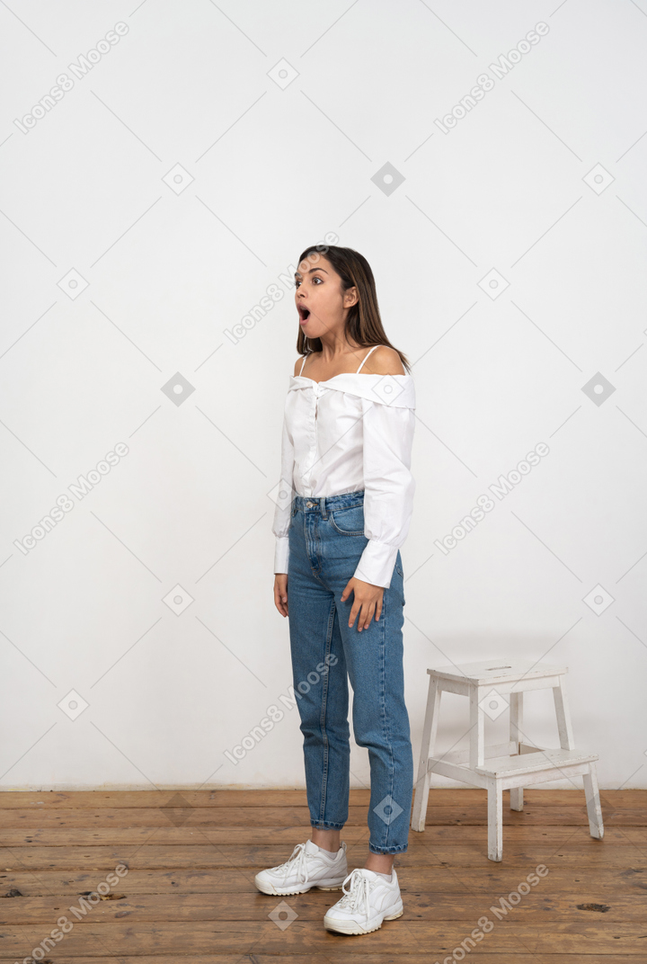 A woman standing on a wooden floor with her mouth open
