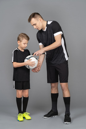 Full-length of a young man coaching little boy