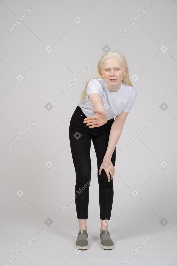 Woman bending forward and reaching arm out