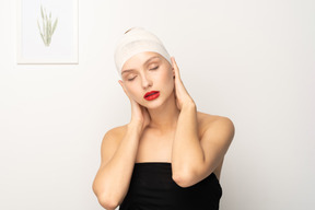 Young woman holding her bandaged head