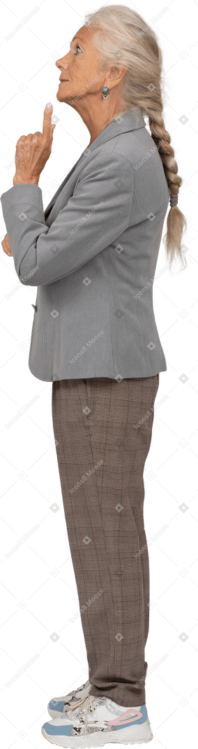 Side view of an old lady in suit showing warning sign