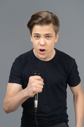 Emotional young man speaking into microphone