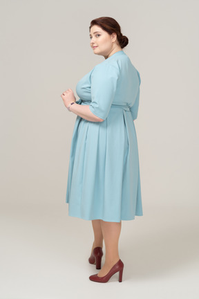 Woman in blue dress posing in profile