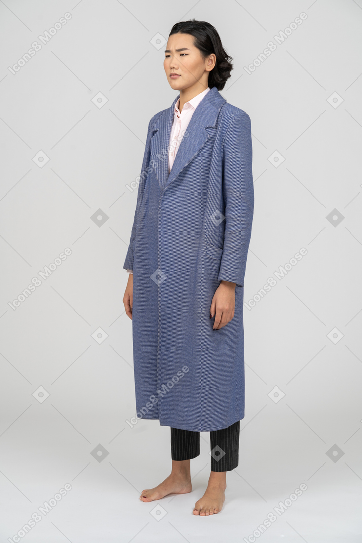 Mulher chateada em pé de casaco azul