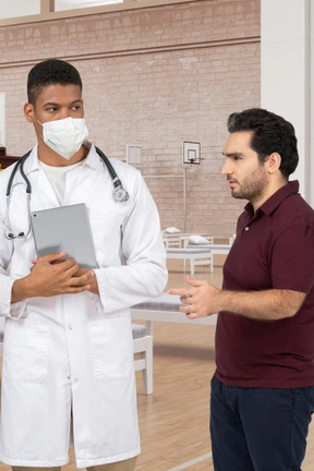 Two men in white lab coats are talking to each other