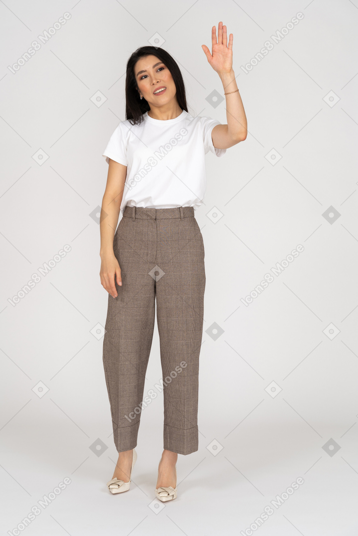 Front view of a young woman in breeches raising her hand
