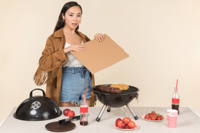 Joven asiática que tiene problemas con la barbacoa