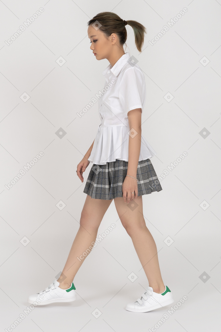Serious asian girl walking sideways