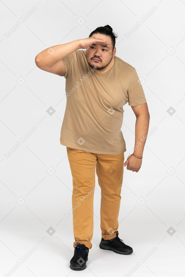 Portrait of plus size asian man looking far away isolated on white