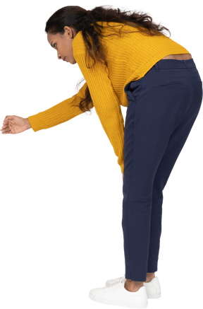 Side view of a girl in casual clothes bending down and explaining something