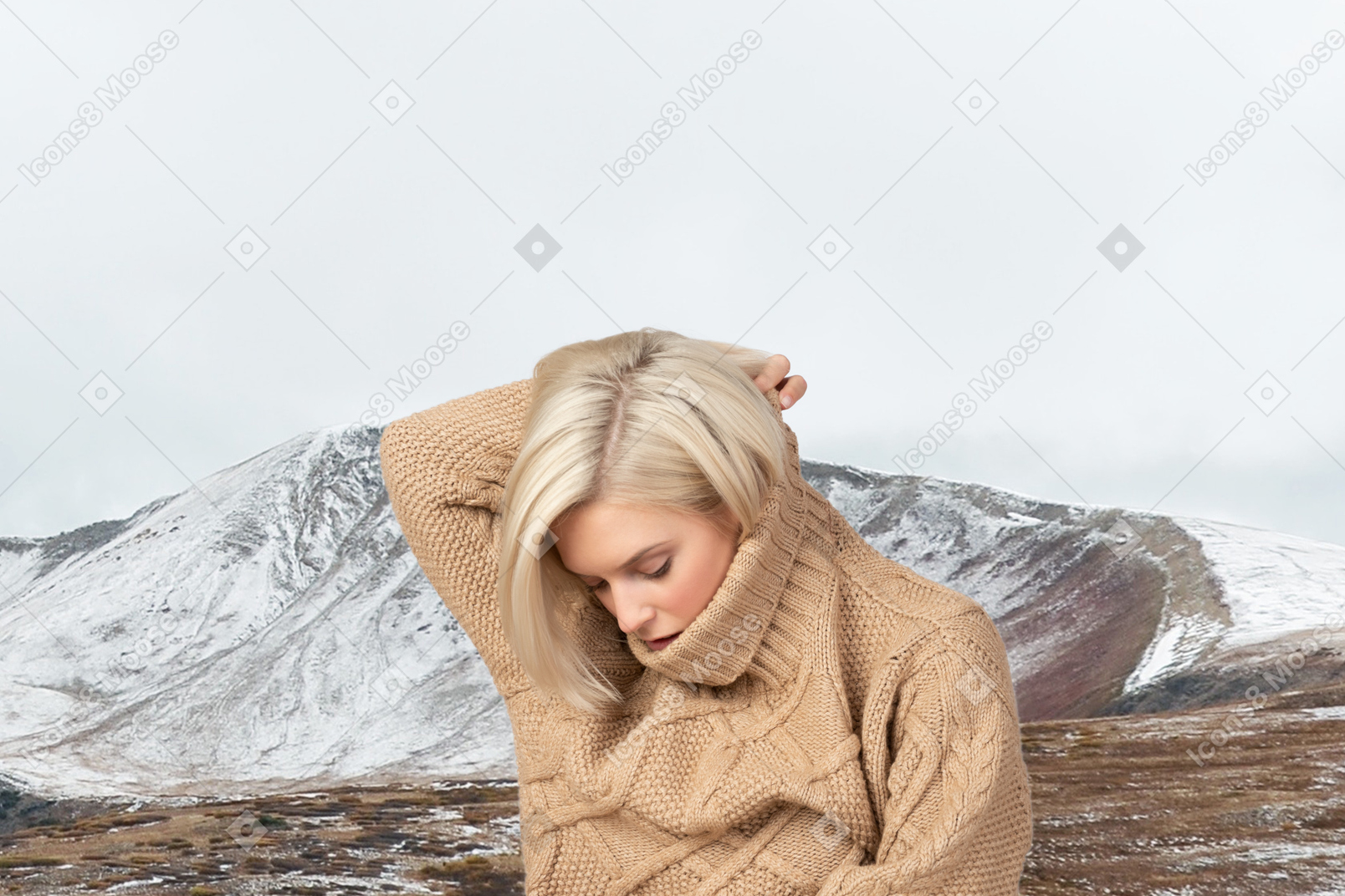 A woman with blond hair wearing a tan sweater