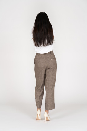 Back view of a young lady in breeches and t-shirt raising hand