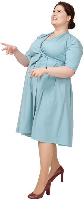 Vue latérale d'une femme en robe bleue faisant des gestes