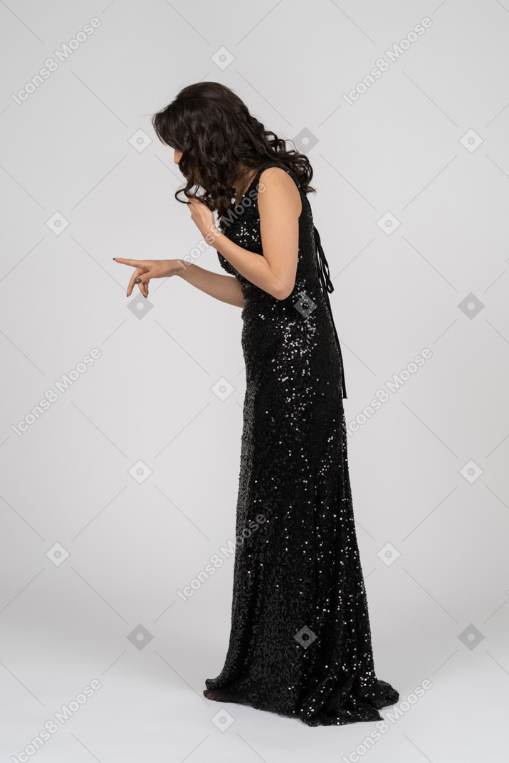 Woman in black evening dress trying to read the sign