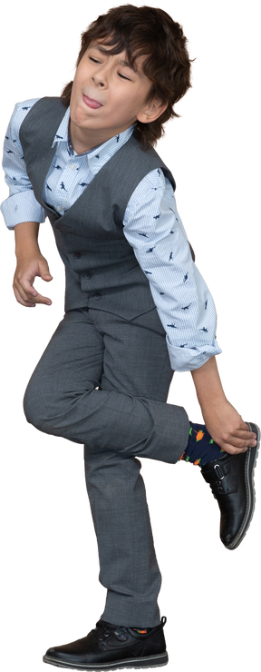一个穿着灰色西装的男孩站在一条腿上的正面图