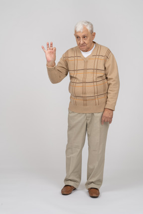 Okサインを示すカジュアルな服装の老人の正面図