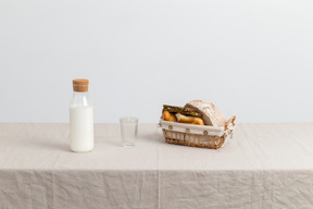 Бутылка молока, пустой стакан молока и хлеба