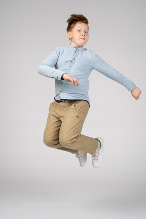 A boy in beige pants jumping in the air