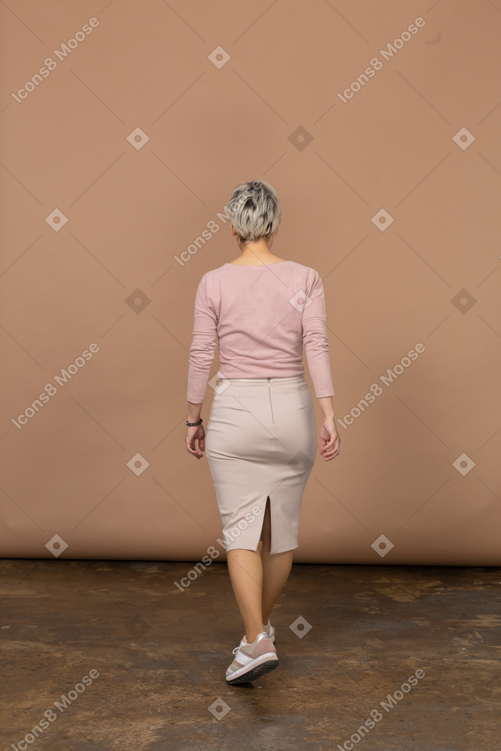 一个穿着休闲服走路的女人的后视图
