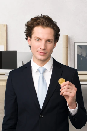 A man in a suit holding a bitcoin