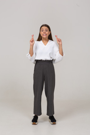 Vista frontal de uma jovem com roupas de escritório cruzando os dedos