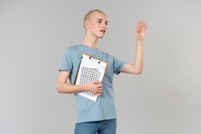 Süßer junger androgyner typ in einem hellblauen t-shirt und blue jeans, auf dem weg zum college