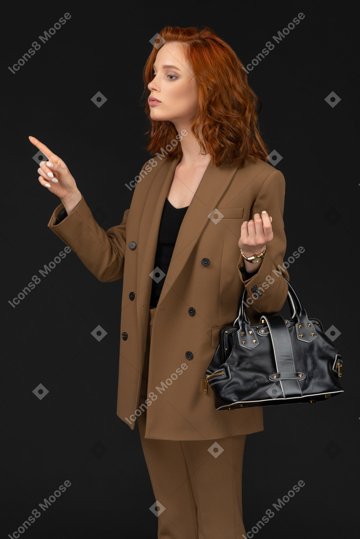 A woman in a black jacket holds a white paper bag