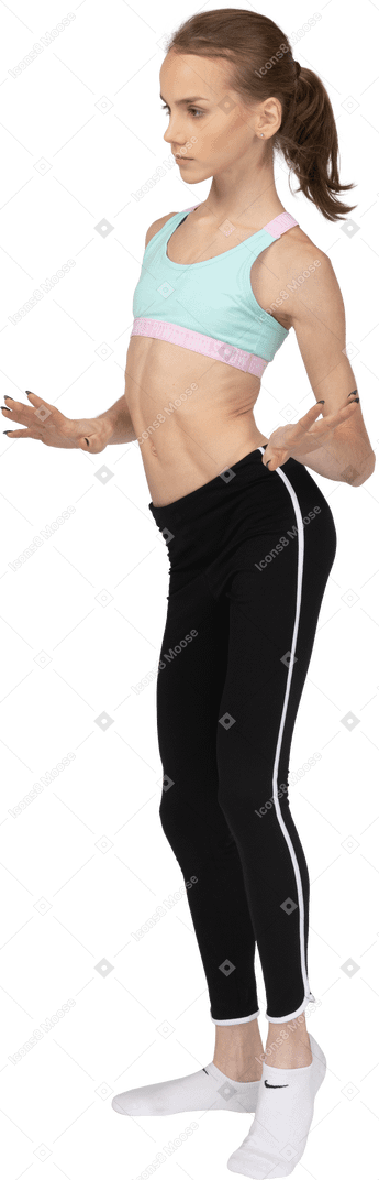Dreiviertelansicht eines jugendlichen mädchens in der sportbekleidung, die beim gestikulieren tanzt