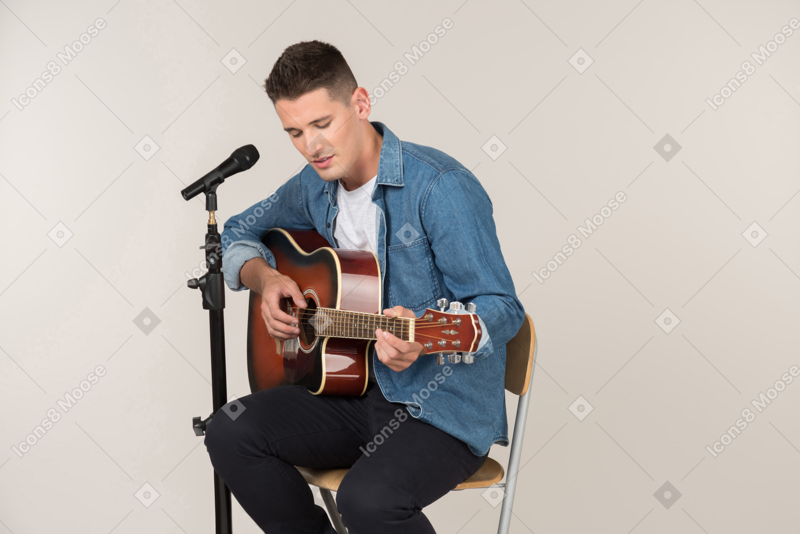 Young stand-up comic playing on guitar and singing in microphone