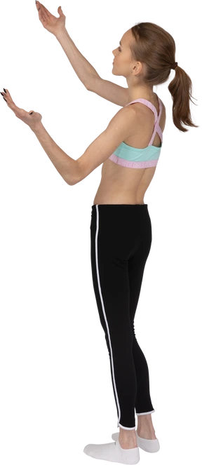 Three-quarter back view of a teen girl in sportswear questioning and raising hands
