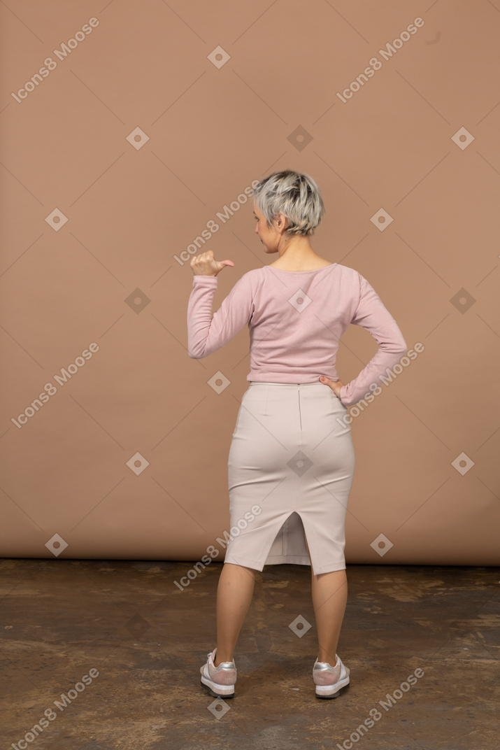一个穿休闲服的女人用手指指着的后视图