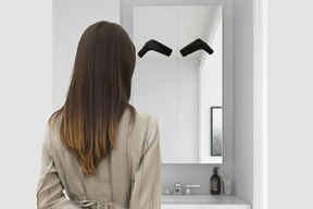 A woman standing in front of a bathroom mirror