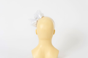 Белый обруч для волос с бантиком на голове манекенщицы