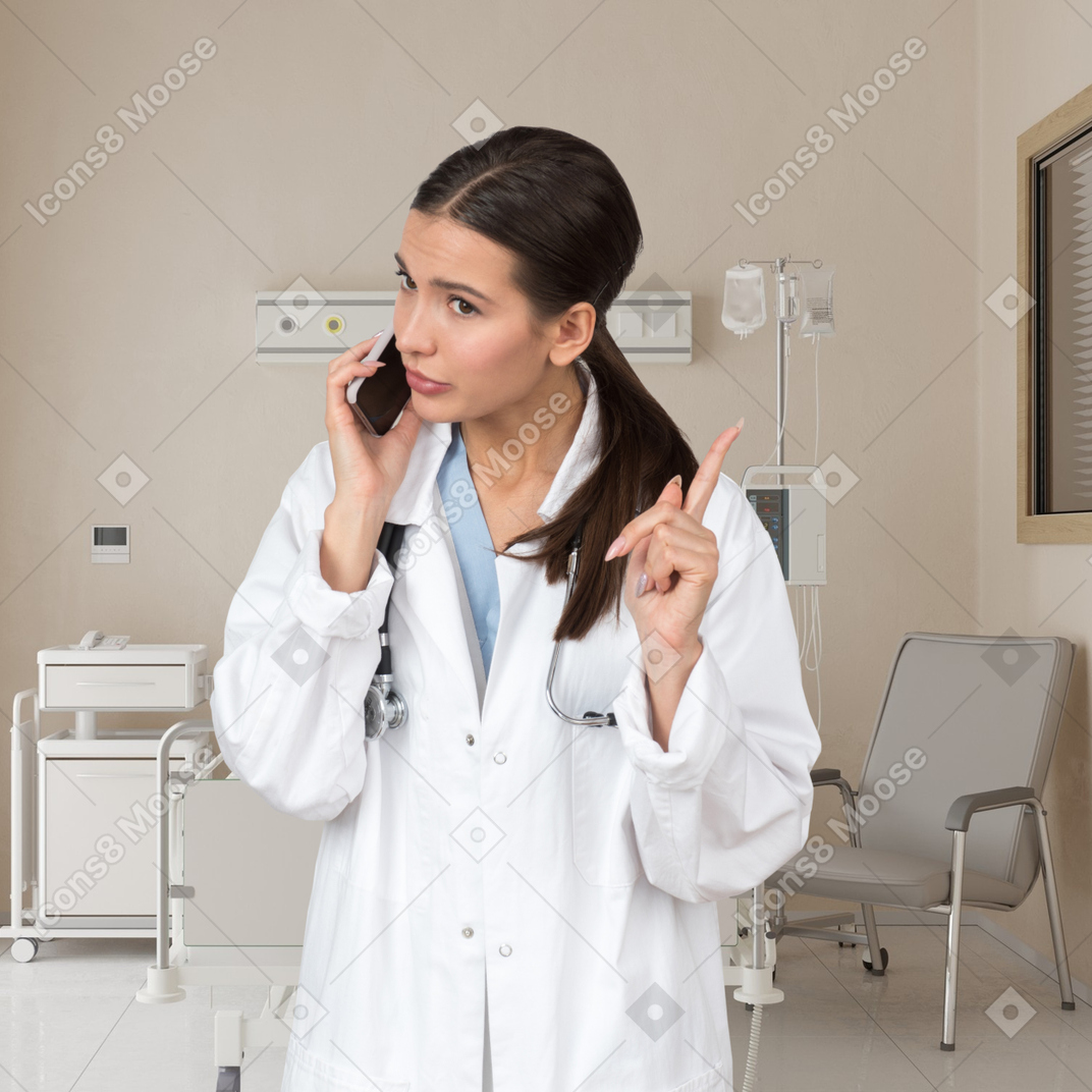 A woman in a white lab coat talking on a cell phone