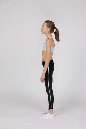Side view of a teen girl in sportswear raising hand and arguing