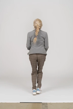 Back view of an old lady in suit jumping
