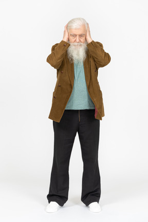 Elderly man covering his ears