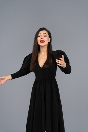 Vista frontal de uma jovem cantora em um vestido preto