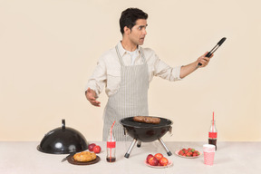 Jeune homme cuisine barbecue