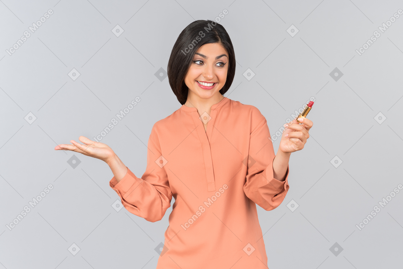 橙色上衣的印地安妇女佩带的唇膏和拿着一个