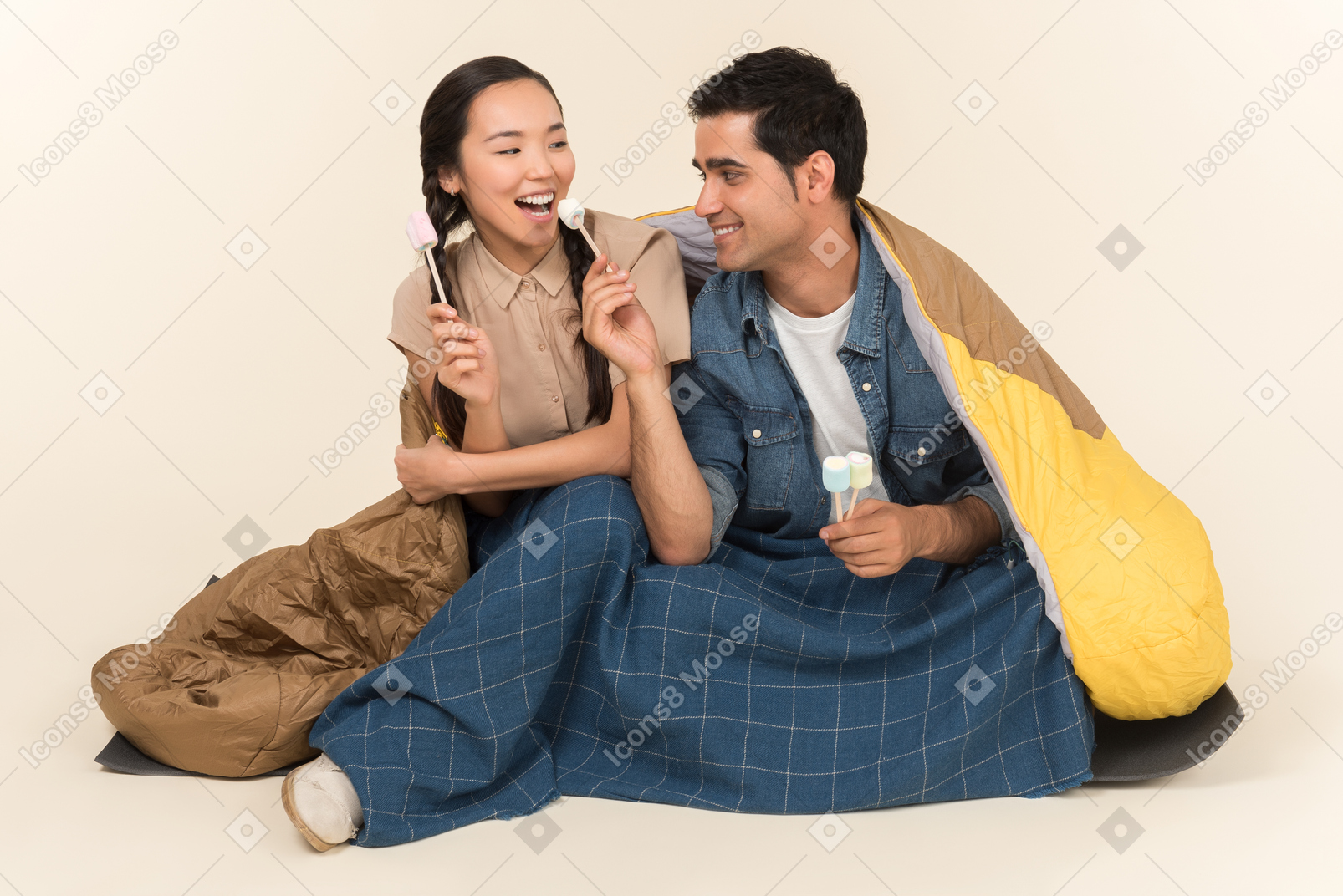 마쉬 멜 로우를 들고 웃는 젊은 interracial 커플