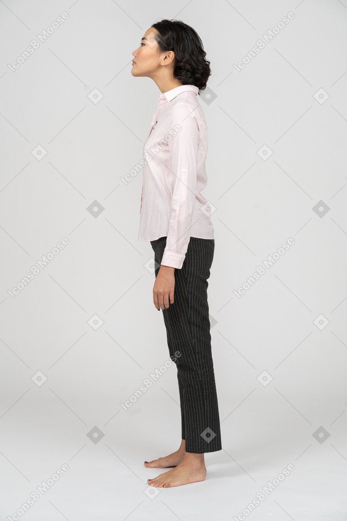 Вид сбоку на женщину в офисной одежде, вытягивающую шею