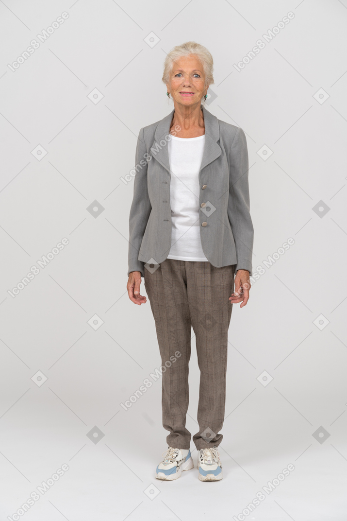 Vue de face d'une vieille femme heureuse en costume regardant la caméra