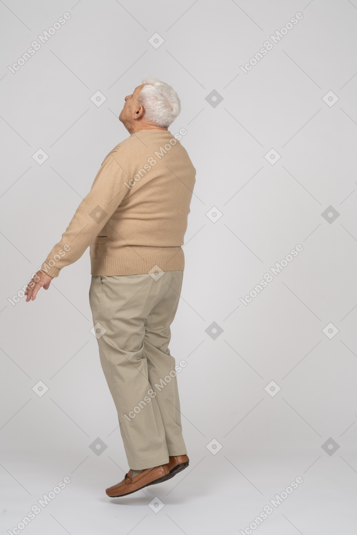 Seitenansicht eines alten mannes in freizeitkleidung beim springen