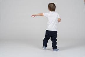 Back view of a boy with a hand put out to the left