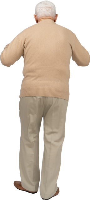 Rear view of an old man in casual clothes scaring someone