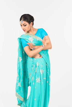 Young indian woman in blue sari standing in dance position